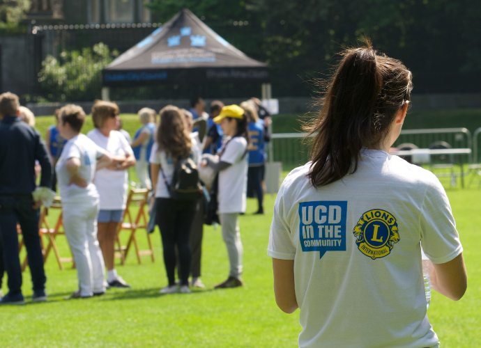 UCD student standing with back to camera wearing a UCD in the Community tshirt